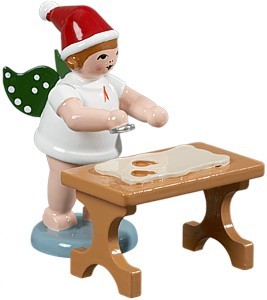 Weihnachtsengel mit Ausstechform am Tisch Weihnachtsengel mit Ausstechform am Tisch